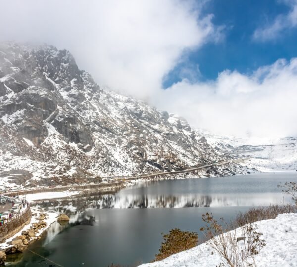 Reflections on Tsomgo Lake surrounded by snow and mountains during Gangtok tour