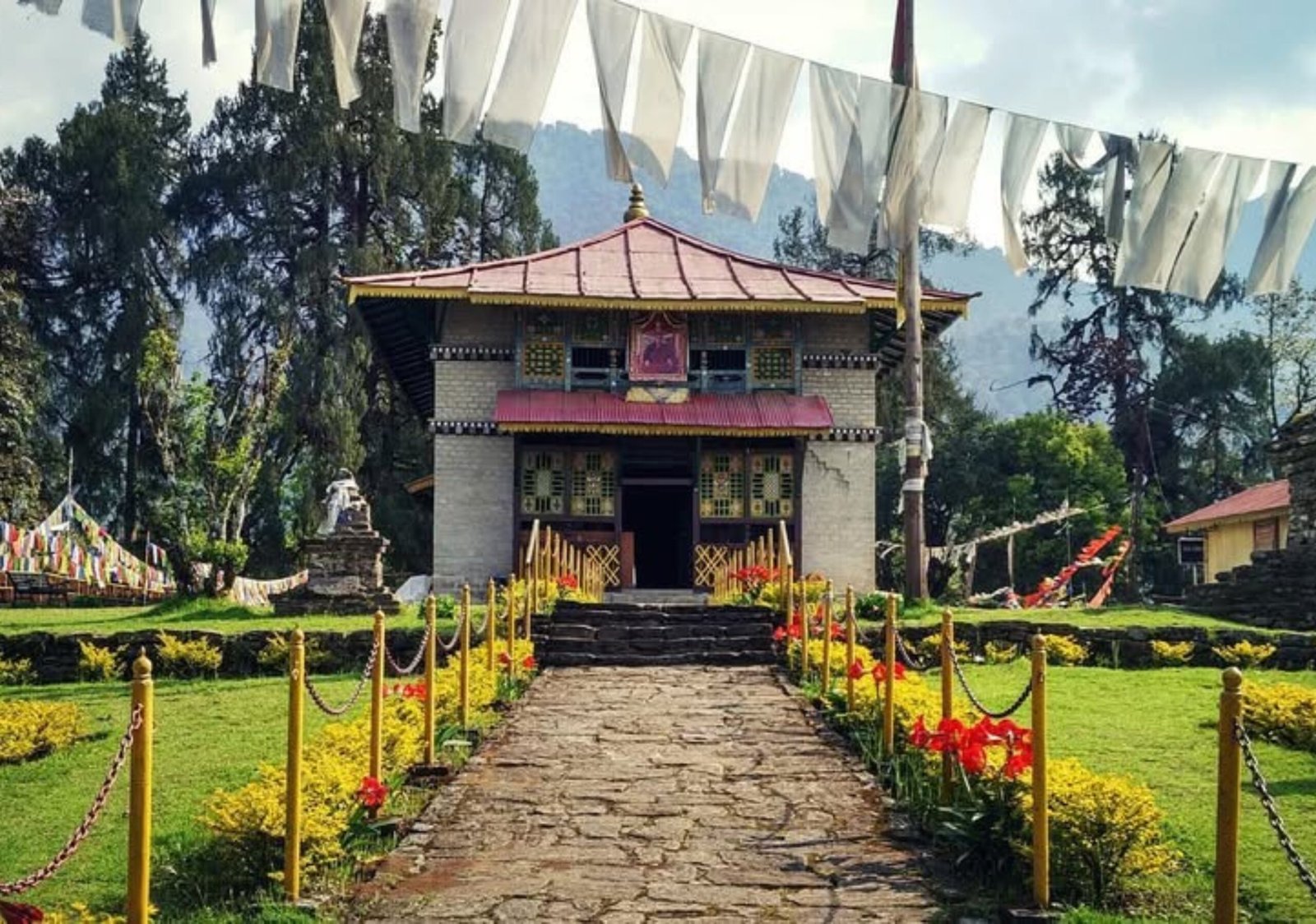 Entrance gate of Dubdi Monastery surrounded by lush greenery in Yuksom